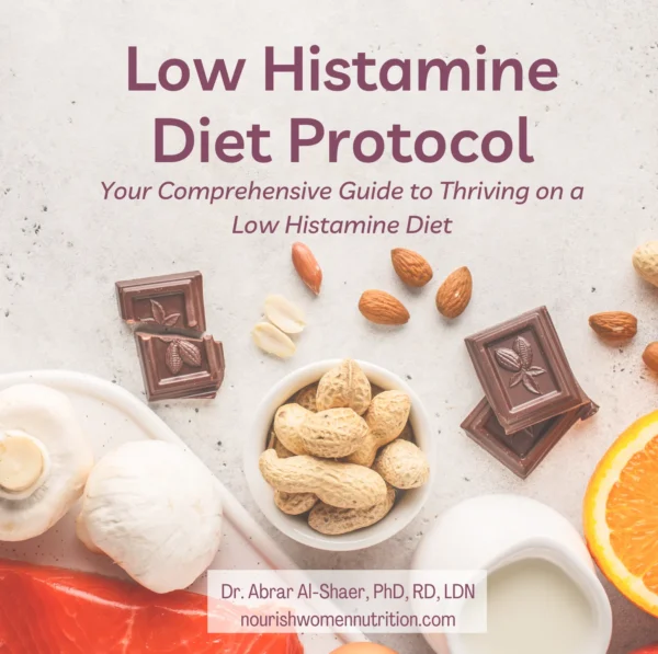 This image displays the cover of a dietary guide titled "Low Histamine Diet Protocol". It is presented as "Your Comprehensive Guide to Thriving on a Low Histamine Diet". The cover features an assortment of foods, including dark chocolate pieces, peanuts, almonds, mushrooms, a sliced orange, and a bowl of milk or cream. These items are artfully arranged on a light-colored, textured surface that resembles a kitchen counter. The cover has a clean and inviting look with warm, natural colors that highlight the food items. At the bottom of the cover, the author's name, "Dr. Abrar Al-Shaer, PhD, RD, LDN", is featured, along with the website "nourishwomennutrition.com", indicating that this is a resource provided by a qualified nutrition professional specialized in women's health.
