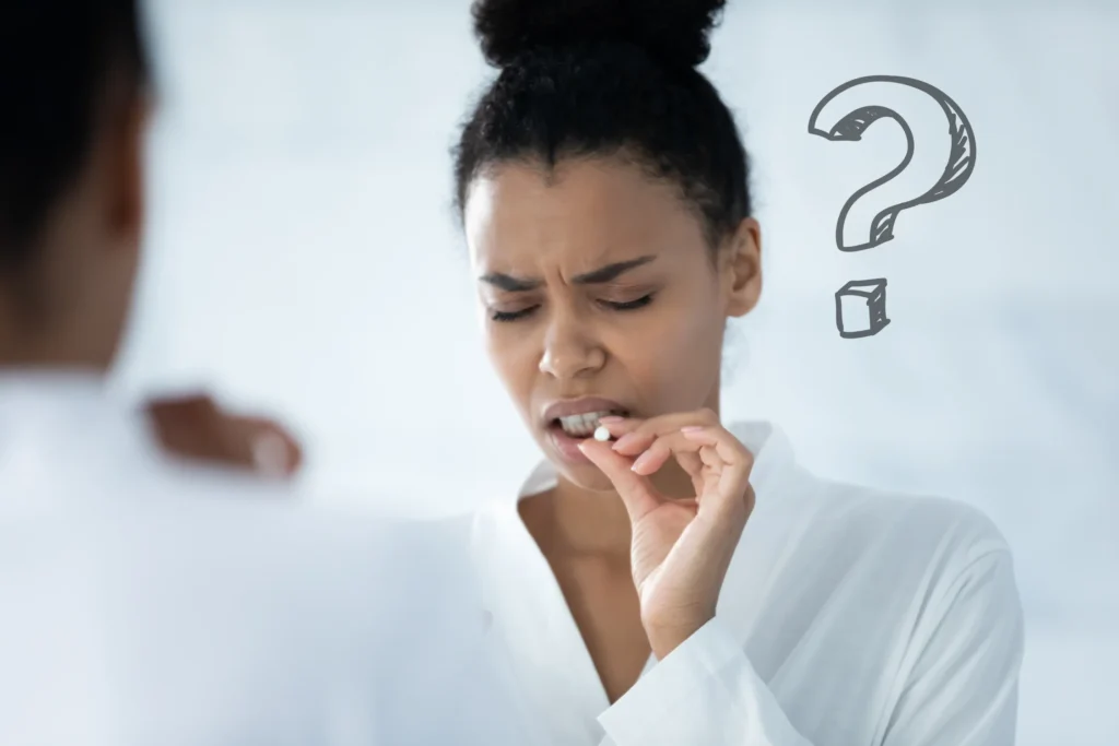 A woman in a white shirt looking uncertainly at a pill she is holding, with a question mark graphic in the background, symbolizing her doubt about pain medication for endometriosis treatment.